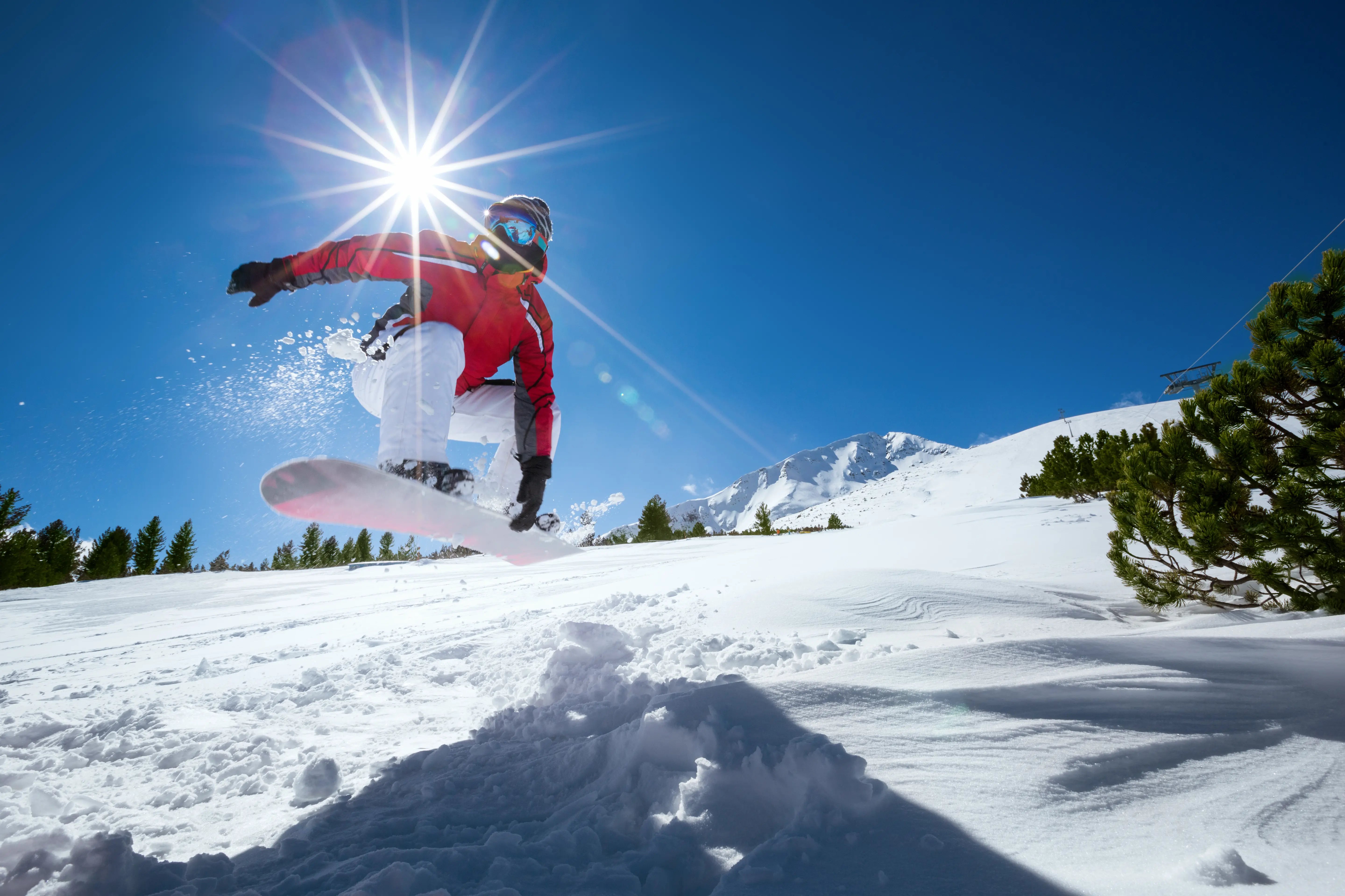 A snowboarder jumping over a jump on a mountain.