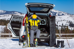 A person sitting in their car getting ready to ski.
