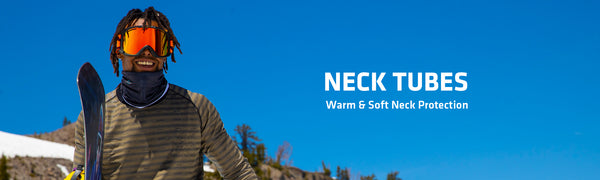 Man carrying snowboard on mountain with neck tube on neck