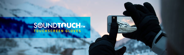 SoundTouch Touchscreen Gloves Text on left and hand wearing gloves touching phone screen taking a picture of snowy mountain view