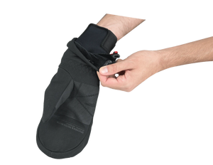 Black mitt being adjusted over black inner glove on a white background